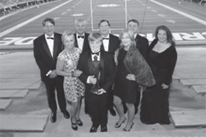 Johnny Johns posing in stand of Bryant-Denny Stadium with his family
