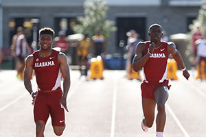 two male track athletes running down lane